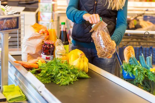 Rolband bij kassa supermarkt met verschillende voedselproducten erop.