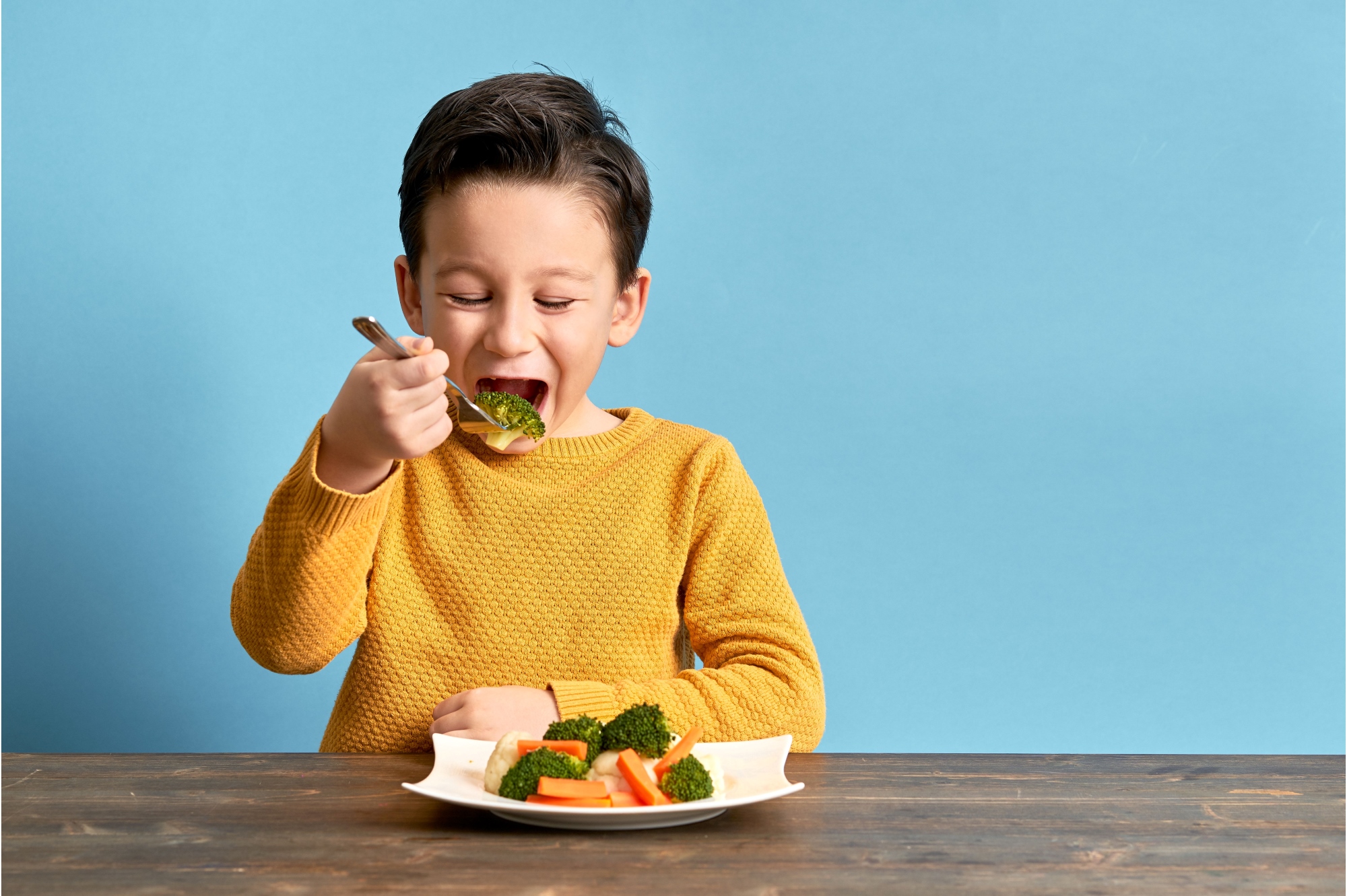 jongetje eet met plezier van een brod met groente